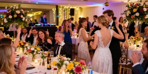 DJ für Hochzeit Berlin, Hochzeitspaar tanzt in fröhlicher Feier mit DJ, festlich dekorierter Saal.